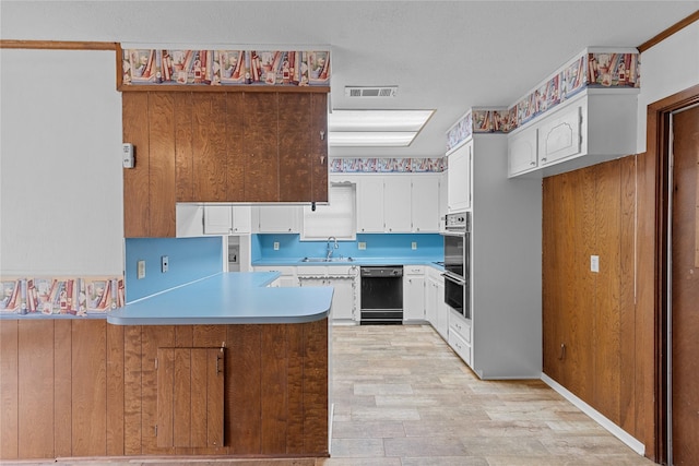 kitchen with sink, white cabinetry, light hardwood / wood-style floors, kitchen peninsula, and stainless steel double oven