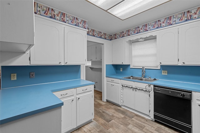 kitchen with sink, white cabinets, black dishwasher, and light wood-type flooring