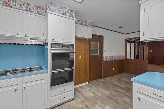 kitchen featuring white cabinetry, crown molding, gas cooktop, and light hardwood / wood-style flooring