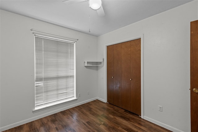 unfurnished bedroom featuring dark wood-type flooring, ceiling fan, and a closet