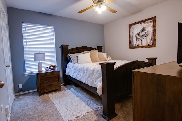 bedroom featuring multiple windows, light colored carpet, and ceiling fan