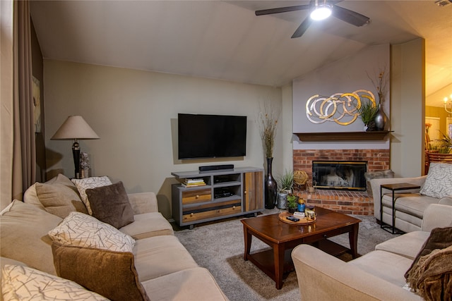 carpeted living room featuring lofted ceiling, ceiling fan with notable chandelier, and a fireplace