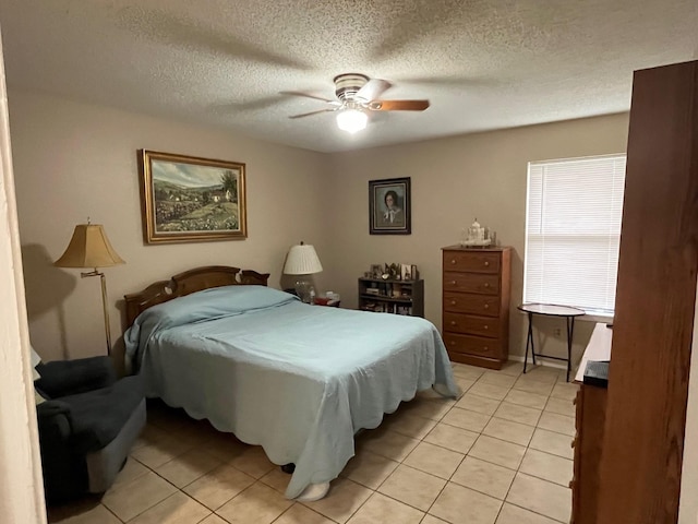 bedroom featuring light tile patterned flooring, a ceiling fan, and a textured ceiling