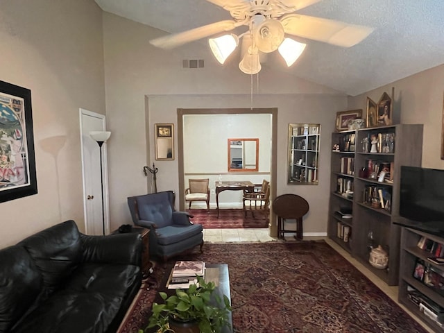 living room with a textured ceiling, vaulted ceiling, and ceiling fan