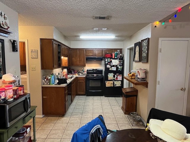 kitchen with visible vents, black appliances, light countertops, light tile patterned floors, and a textured ceiling