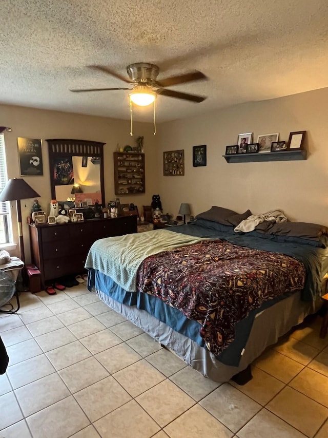 bedroom featuring tile patterned flooring, a textured ceiling, and ceiling fan