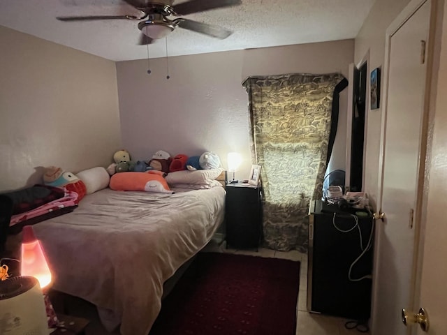 bedroom featuring a ceiling fan and a textured ceiling