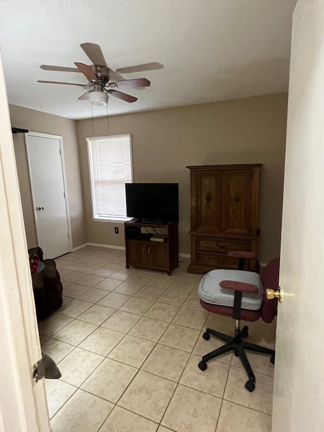 sitting room with ceiling fan, baseboards, and light tile patterned flooring