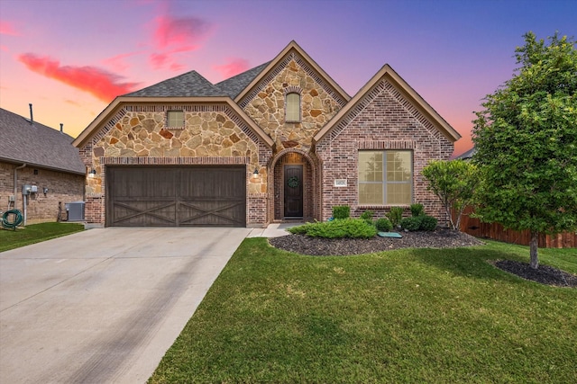 view of front of property featuring cooling unit, a garage, and a yard