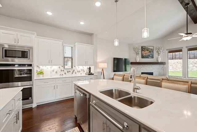 kitchen featuring sink, hanging light fixtures, appliances with stainless steel finishes, a wealth of natural light, and white cabinets