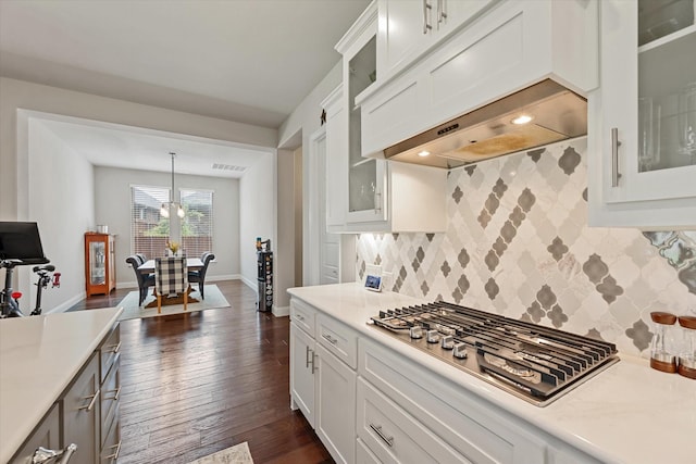 kitchen with stainless steel gas stovetop, white cabinetry, hanging light fixtures, dark wood-type flooring, and custom range hood