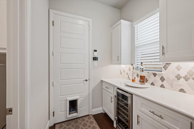 interior space with white cabinetry, beverage cooler, dark hardwood / wood-style flooring, and decorative backsplash