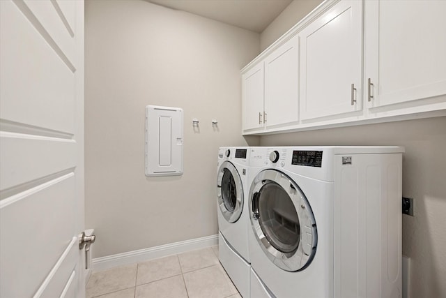 laundry room with light tile patterned floors, washing machine and dryer, and cabinets