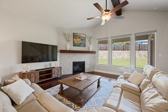 living room with a fireplace, hardwood / wood-style flooring, vaulted ceiling, and ceiling fan