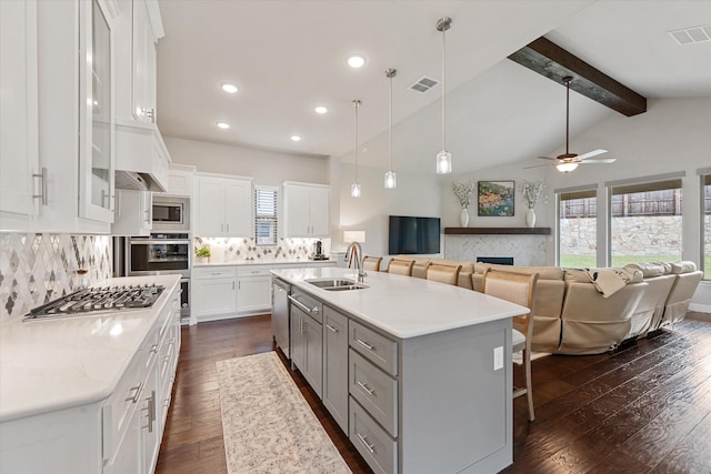 kitchen featuring sink, an island with sink, a breakfast bar area, and white cabinets