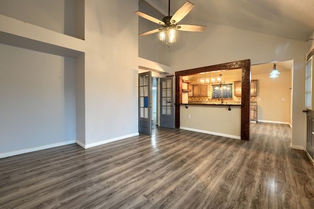 unfurnished living room with dark wood-type flooring, high vaulted ceiling, and ceiling fan