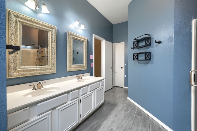 bathroom featuring hardwood / wood-style flooring, vanity, and walk in shower