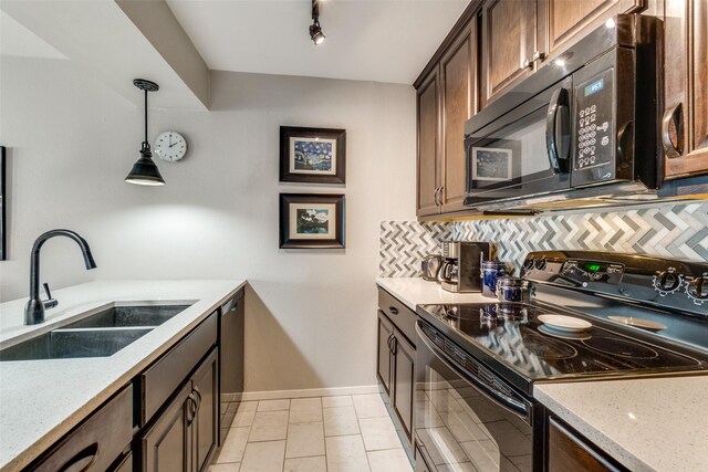 kitchen with sink, hanging light fixtures, light stone counters, tasteful backsplash, and black appliances