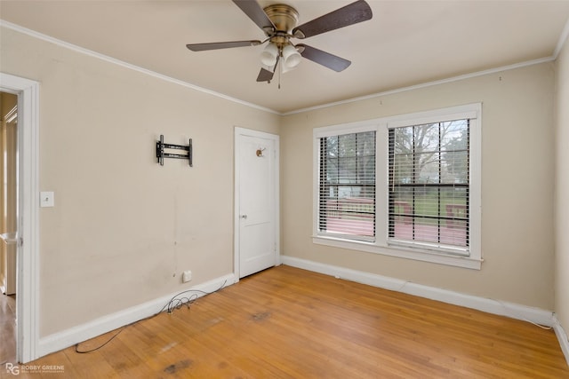 empty room with hardwood / wood-style floors, ornamental molding, and ceiling fan