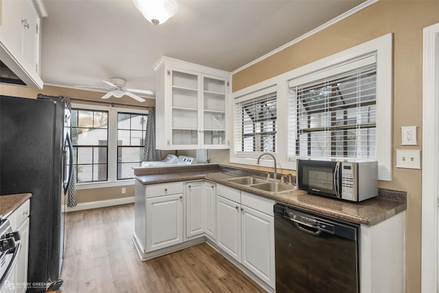 kitchen featuring sink, light hardwood / wood-style flooring, white cabinets, and black appliances