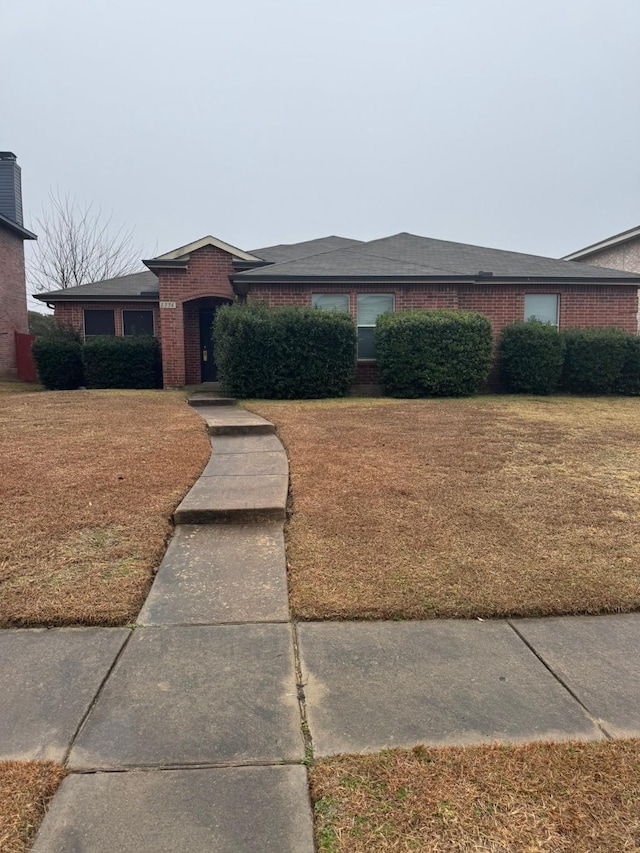 ranch-style home featuring a front lawn