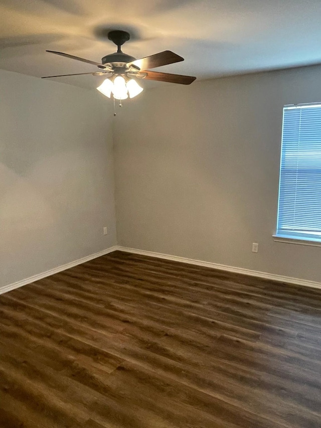 unfurnished room featuring dark wood-type flooring and ceiling fan