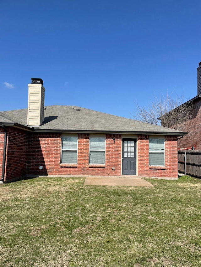 rear view of property featuring a yard and a patio area