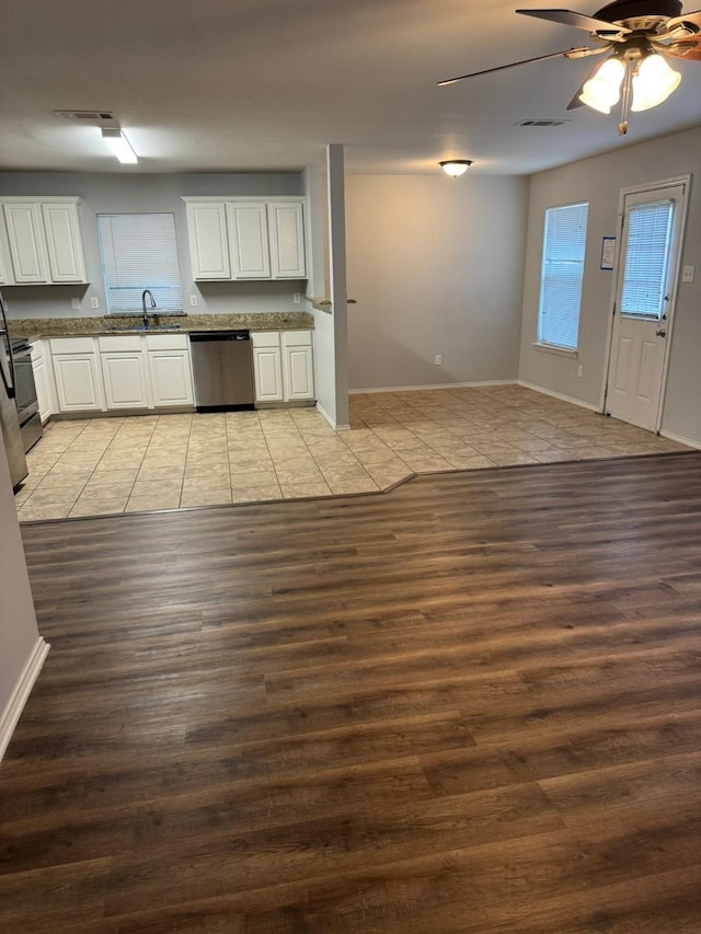 kitchen featuring sink, light wood-type flooring, stainless steel dishwasher, ceiling fan, and white cabinets