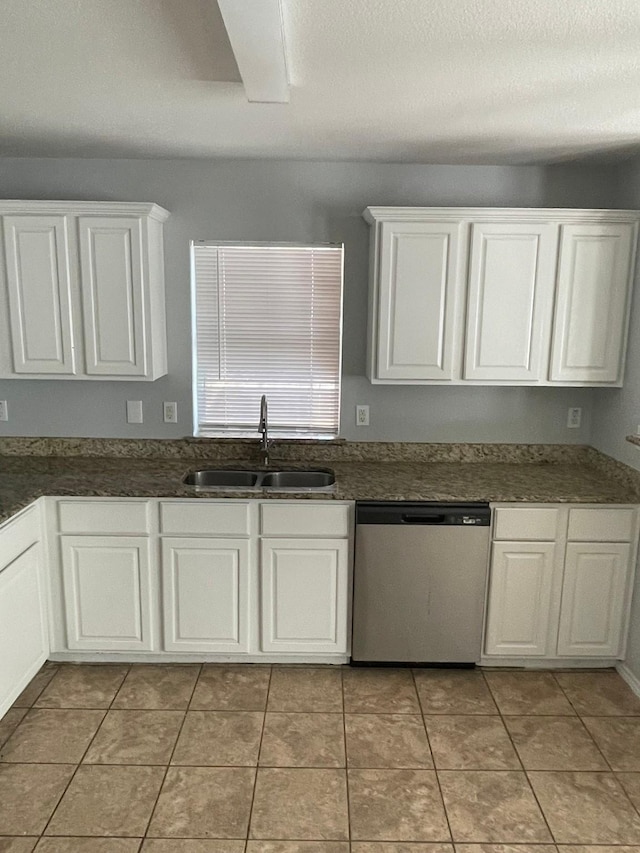 kitchen with white cabinetry, stainless steel dishwasher, sink, and light tile patterned floors