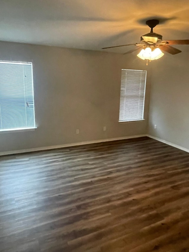 empty room with dark wood-type flooring and ceiling fan