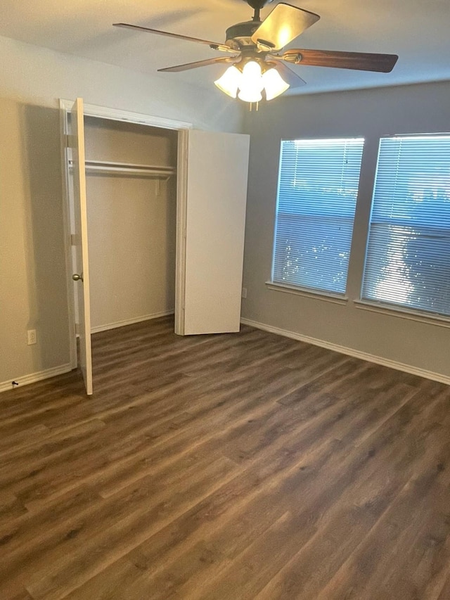 unfurnished bedroom with dark hardwood / wood-style flooring, a closet, and ceiling fan