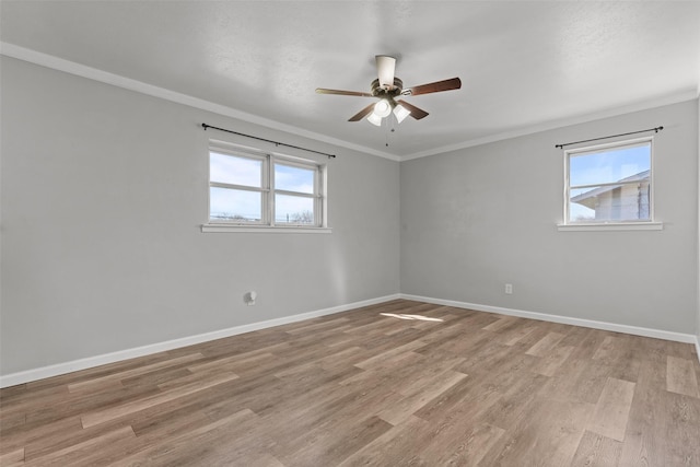 empty room featuring ornamental molding, ceiling fan, and light wood-type flooring