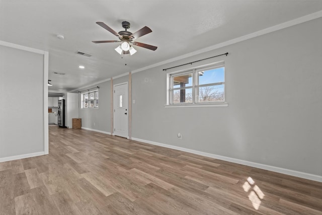 unfurnished living room featuring ornamental molding, ceiling fan, and light hardwood / wood-style flooring