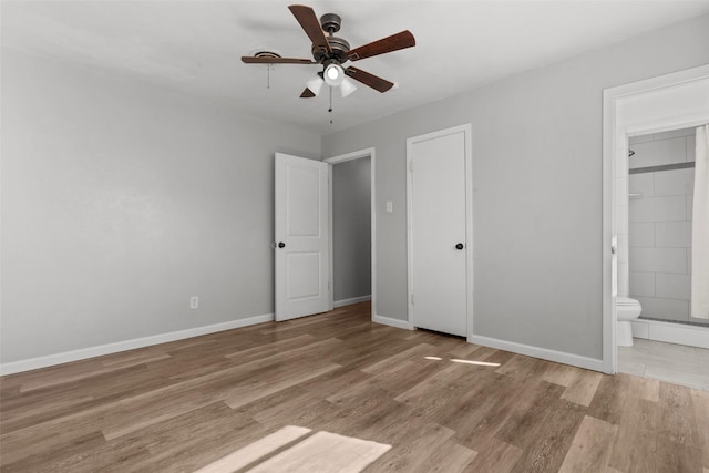 unfurnished bedroom featuring ensuite bathroom, ceiling fan, and light wood-type flooring