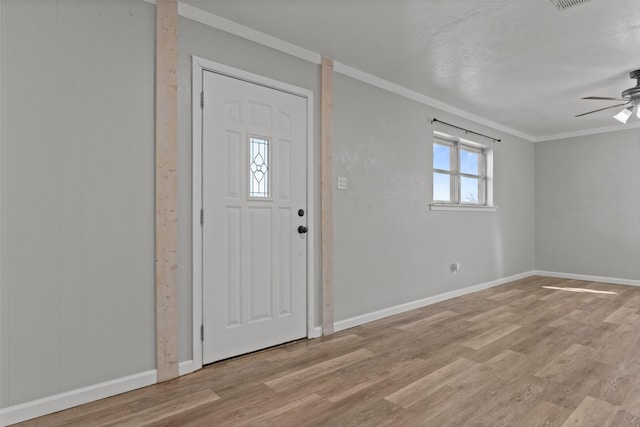 entryway featuring ceiling fan, ornamental molding, and light wood-type flooring