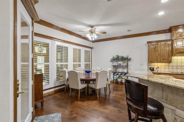 dining space with ornamental molding, dark hardwood / wood-style floors, a textured ceiling, and ceiling fan