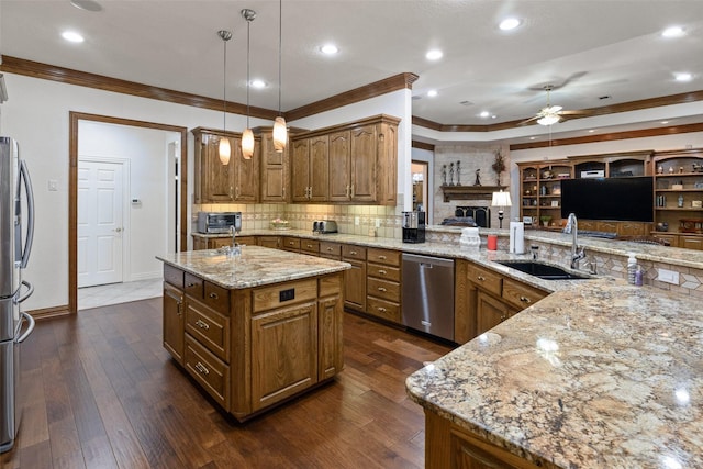 kitchen with a kitchen island, appliances with stainless steel finishes, pendant lighting, dark hardwood / wood-style floors, and sink