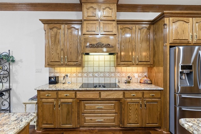 kitchen with stainless steel refrigerator with ice dispenser, black electric stovetop, light stone countertops, and backsplash