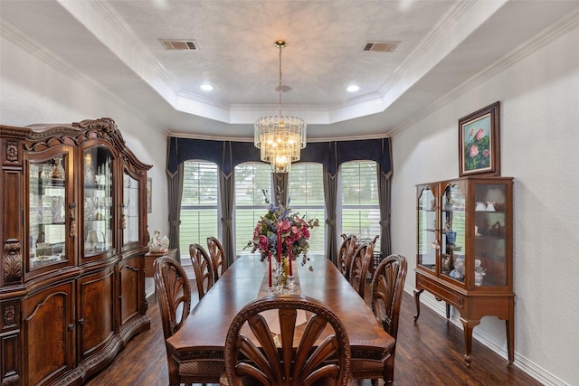 dining area with an inviting chandelier, crown molding, dark wood-type flooring, and a raised ceiling