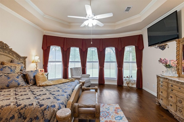 bedroom featuring dark hardwood / wood-style flooring, a tray ceiling, and crown molding