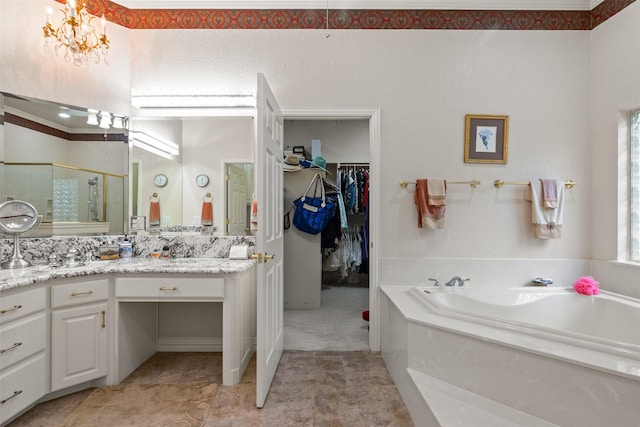 bathroom with independent shower and bath, vanity, and a notable chandelier