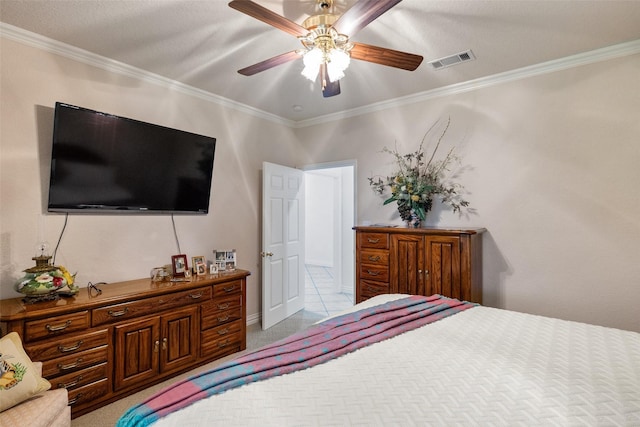 carpeted bedroom with ceiling fan and ornamental molding