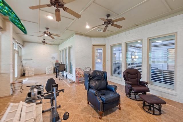 workout room featuring light tile patterned floors and brick wall