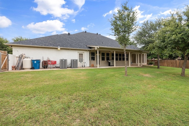 back of property with a patio area, central air condition unit, and a lawn