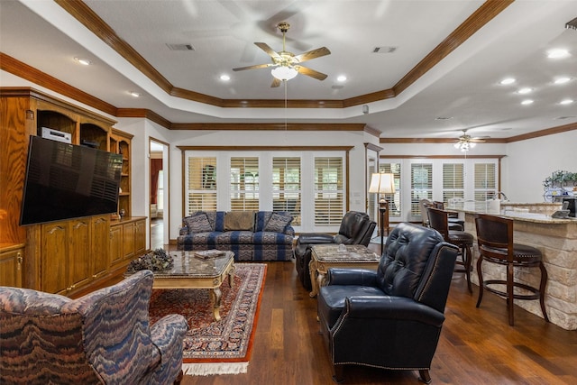 living room featuring a raised ceiling, ornamental molding, ceiling fan, and dark hardwood / wood-style flooring