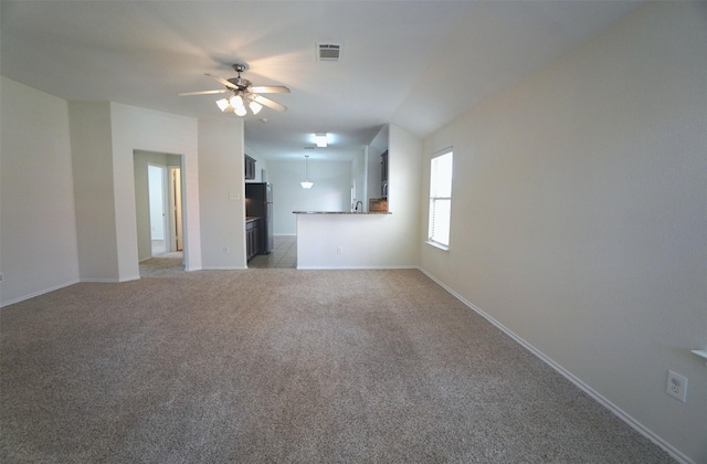 unfurnished living room featuring carpet floors and ceiling fan