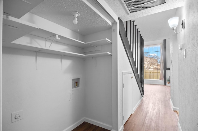 laundry room featuring wood finished floors, hookup for a washing machine, visible vents, and baseboards