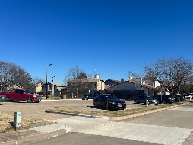 view of road with street lights, a residential view, and curbs