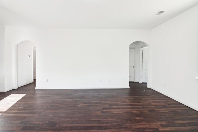 unfurnished room with dark wood-type flooring