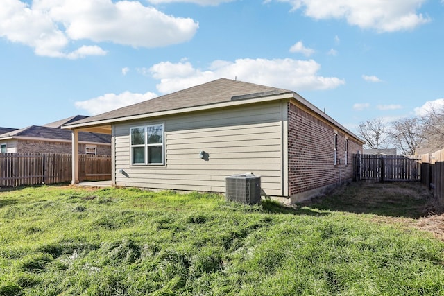 back of house featuring central AC and a lawn